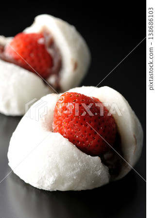 Strawberry daifuku photographed against a black background 138686103