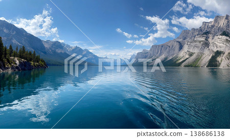 A breathtaking view turquoise lake waters reflecting snow-capped peaks. The scene features dense pine forests and soft morning mist drifting across the rugged Canadian Rockies. 138686138