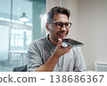 Skilled Professional Records Cheerful Voice Message While Casually Resting In Contemporary Office Environment 138686367