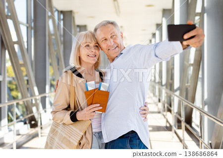 Happy mature couple taking a selfie with smartphone at airport 138686864