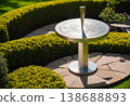 Modern Sundial Sculpture in Hedge Garden 138688893