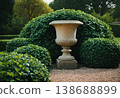Classic Stone Urn Planter in Manicured Garden 138688899