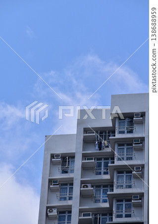 Exterior of residential building in Hong Kong with skyscape. Details of modern architecture. Building abstract. Building background. Exterior of residential building in Hong Kong with skyscape. Details of modern architecture. Building abstract. Building background. 138688959