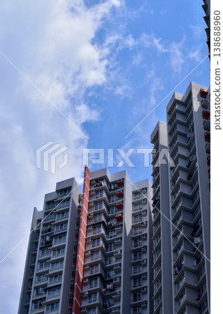 Exterior of residential building in Hong Kong with skyscape. Details of modern architecture. Building abstract. Building background. Exterior of residential building in Hong Kong with skyscape. Details of modern architecture. Building abstract. Building background. 138688960