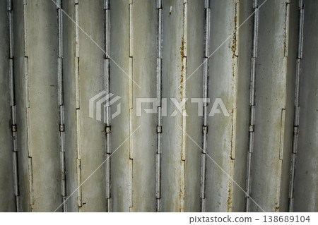 Close-up of old shutter door. Metallic rusty texture stripe pattern on door. For background. Close-up of old shutter door. Metallic rusty texture stripe pattern on door. For background. 138689104