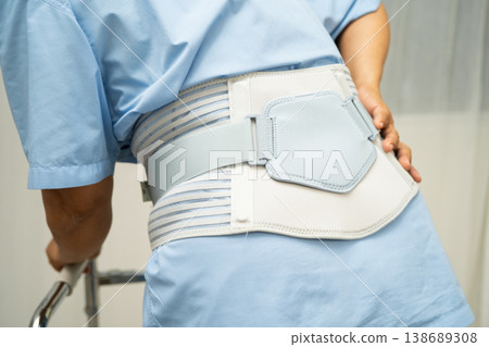 Asian senior pain back wearing elastic support belt with walker. Asian senior pain back wearing elastic support belt with walker. 138689308