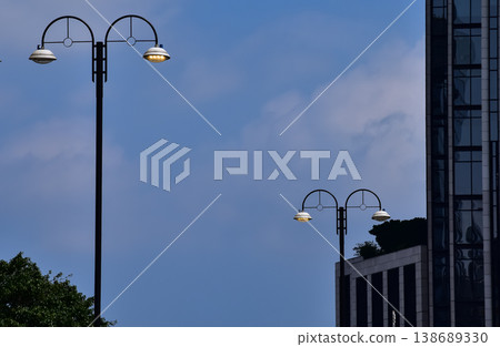Close-up of the streetlight with blue sky background. City light in the street. Cityscape and downtown scene. Close-up of the streetlight with blue sky background. City light in the street. Cityscape and downtown scene. 138689330