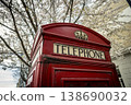 Classic British telephone box under spring blossom 138690032