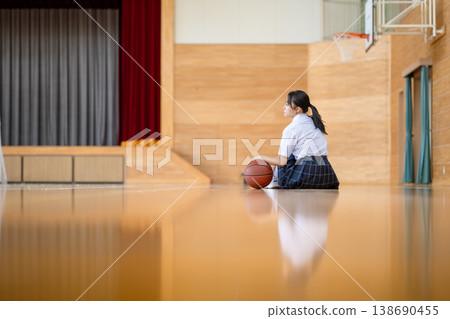 Female students sitting with a basketball in the gymnasium Female students sitting with a basketball in the gymnasium 138690455