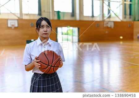 一名高中女生手持籃球,照片中可以看到她的臉部和上半身。 一名高中女生手持籃球,照片中可以看到她的臉部和上半身。 138690458