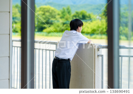 一名高中男生從陽台上向外眺望。 138690491