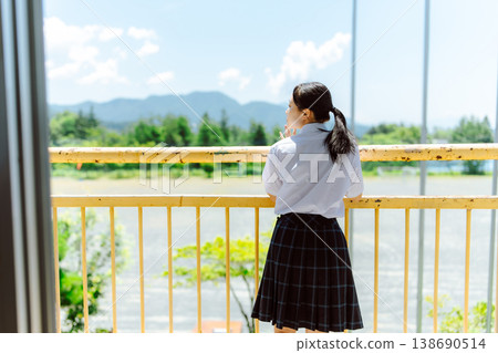 A high school girl gazes at the view from her balcony. A high school girl gazes at the view from her balcony. 138690514