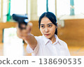一名高中女生手持槍支，側身看向一旁。 138690535