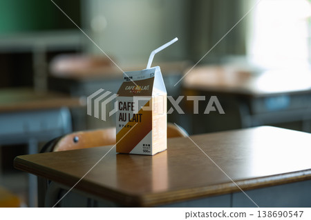 A paper carton of café au lait placed on a classroom desk. 138690547