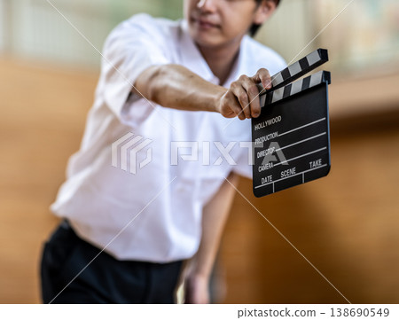 一名男學生拿著場記板。 一名男學生拿著場記板。 138690549