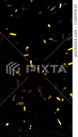 Flying golden confetti on black background. Shiny particles suspended in the air with dramatic lighting, creating a festive, luxury and celebratory atmosphere. Flying golden confetti on black background. Shiny particles suspended in the air with dramatic lighting, creating a festive, luxury and celebratory atmosphere. 138690616