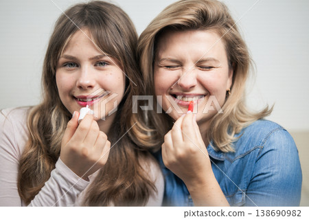 Mother and daughter applying makeup and having fun Mother and daughter applying makeup and having fun 138690982
