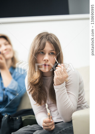 Young girl applying makeup concealer under eye Young girl applying makeup concealer under eye 138690995