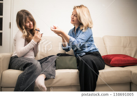 Two women sharing a moment applying makeup Two women sharing a moment applying makeup 138691005