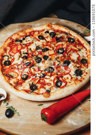 Traditional Italian pinsa romana capricciosa topped with tomato sauce mozzarella ham black olives artichokes and mushrooms on a wooden board. Traditional Italian pinsa romana capricciosa topped with tomato sauce mozzarella ham black olives artichokes and mushrooms on a wooden board. 138691078