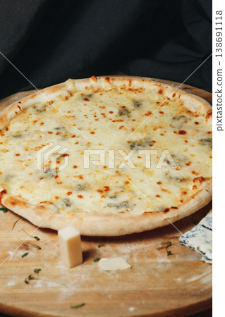 Traditional Italian pizza quattro formaggi with melted mozzarella gorgonzola parmesan and emmental cheese on a rustic wooden board. Traditional Italian pizza quattro formaggi with melted mozzarella gorgonzola parmesan and emmental cheese on a rustic wooden board. 138691118