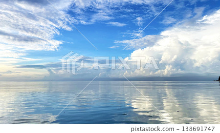 The sea at Funakoshi Fishing Port in Ishigaki Island: A fantastical scene of the blue sky and clouds reflected on the mirror-like surface of the water. 138691747