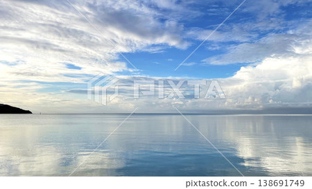 The sea at Funakoshi Fishing Port in Ishigaki Island: A fantastical scene of the blue sky and clouds reflected on the mirror-like surface of the water. The sea at Funakoshi Fishing Port in Ishigaki Island: A fantastical scene of the blue sky and clouds reflected on the mirror-like surface of the water. 138691749