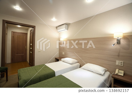 Modern hotel room interior with two twin beds and warm lighting Modern hotel room interior with two twin beds and warm lighting 138692157