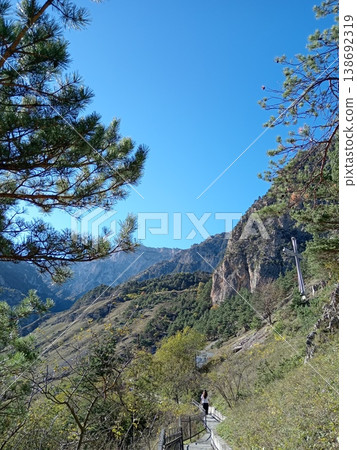 Bright summer day landscape of the Caucasus Mountains, North Ossetia, Russia. Sunlit green slopes, jagged ridges and peaceful highland scenery stretching to the horizon 138692319