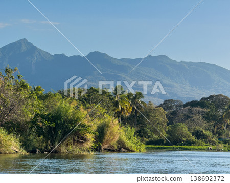Lush landscape with mountains and river under clear sky in daytime Lush landscape with mountains and river under clear sky in daytime 138692372