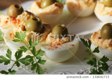 Classic Deviled Eggs with Olives and Paprika	 138692715