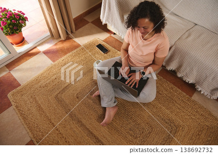 View from above of a woman working on laptop at home, focused remote work View from above of a woman working on laptop at home, focused remote work 138692732