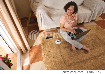 Woman with laptop and coffee relaxing at home, remote work concept Woman with laptop and coffee relaxing at home, remote work concept 138692733
