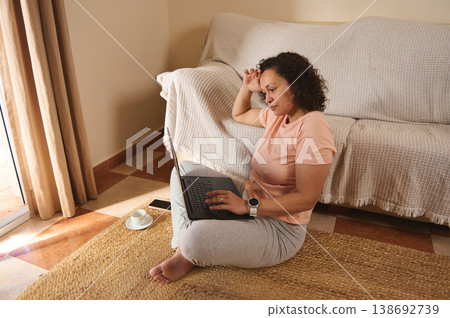 Top view woman working on laptop sitting on floor at home 138692739