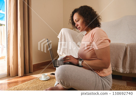 Focused woman working on laptop at home 138692740