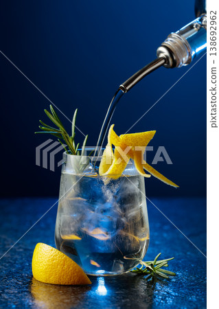 Gin and tonick cocktail in a fogged up glass on a black table. 138692962