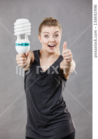 Woman holding eco modern light bulb Woman holding eco modern light bulb 138692996