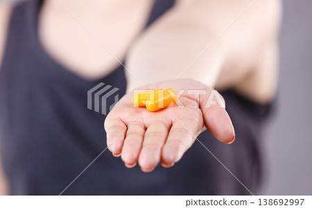 Woman holding protective earplugs Woman holding protective earplugs 138692997