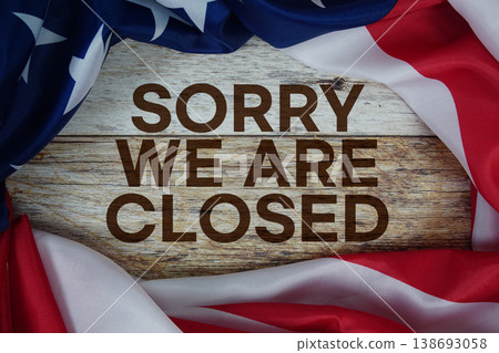 American flag with "Sorry We're Closed" on wooden background 138693058
