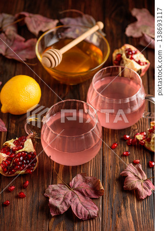 Two Cups of Autumn Pomegranate Tea with Lemon and Ginger on Rustic Table Two Cups of Autumn Pomegranate Tea with Lemon and Ginger on Rustic Table 138693117