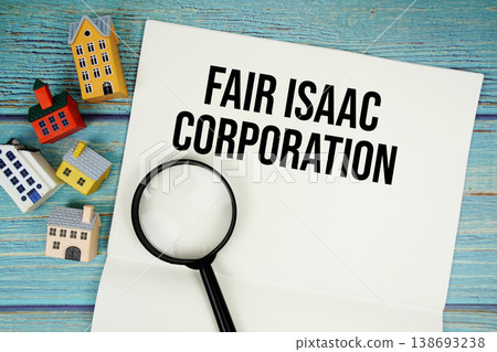 Notepad with "FICO Fair Isaac Corporation" with magnifying glass and house model on wooden background Notepad with "FICO Fair Isaac Corporation" with magnifying glass and house model on wooden background 138693238