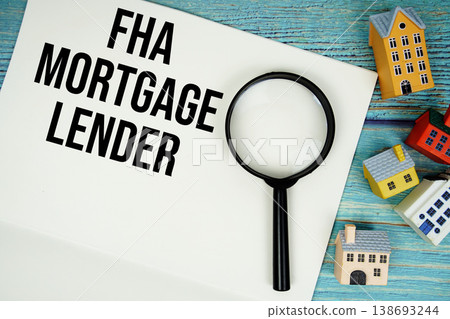 Notepad with "FHA Mortgage Lender" with magnifying glass and house model on wooden background 138693244