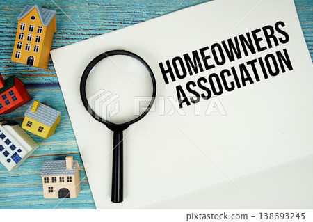 Notepad with "HOA Homeowners Association" with magnifying glass and house model on wooden background Notepad with "HOA Homeowners Association" with magnifying glass and house model on wooden background 138693245
