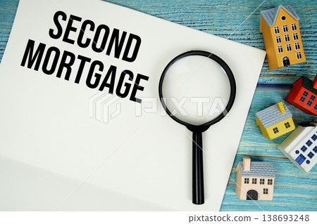 Notepad with "Second Mortgage" with magnifying glass and house model on wooden background Notepad with "Second Mortgage" with magnifying glass and house model on wooden background 138693248