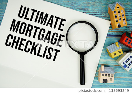 Notepad with "Ultimate Mortgage Checklist" with magnifying glass and house model on wooden background Notepad with "Ultimate Mortgage Checklist" with magnifying glass and house model on wooden background 138693249