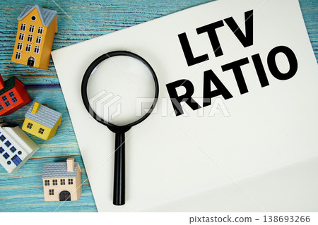 Notepad with "LTV Ratio" with magnifying glass and house model on wooden background Notepad with "LTV Ratio" with magnifying glass and house model on wooden background 138693266