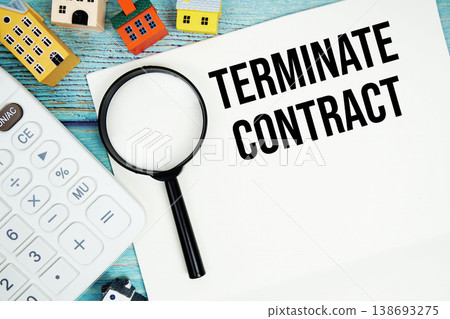 Notepad with "Terminate Contract" with Calculator, magnifying glass and house model on wooden background 138693275