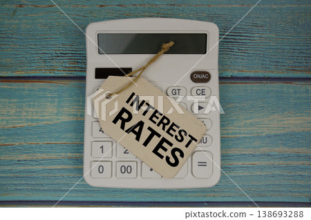 Price tag with "INTEREST RATES" on calculator on a rustic blue wooden surface Price tag with "INTEREST RATES" on calculator on a rustic blue wooden surface 138693288
