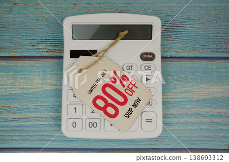 Sale 80% off Shop Now with price tag and calculator on wooden background Sale 80% off Shop Now with price tag and calculator on wooden background 138693312