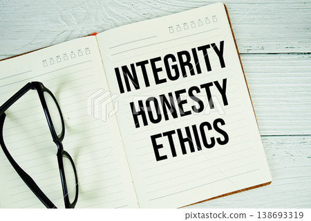 Notepad with message "Integrity, Honesty, And Ethics" and eyeglass on wooden background Notepad with message "Integrity, Honesty, And Ethics" and eyeglass on wooden background 138693319